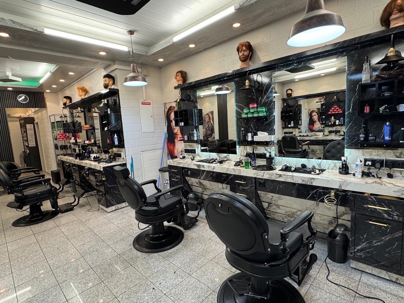 Blick auf die Friseurplätze und großen Spiegel im Salon